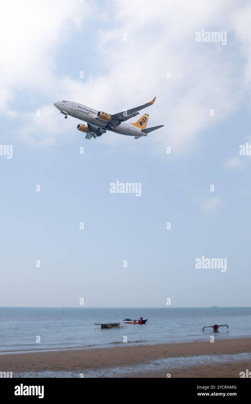 RGA Black Stone Airlines Cargo plane vole bas au-dessus de la plage de Balikpapan pour se préparer à l'atterrissage Banque D'Images