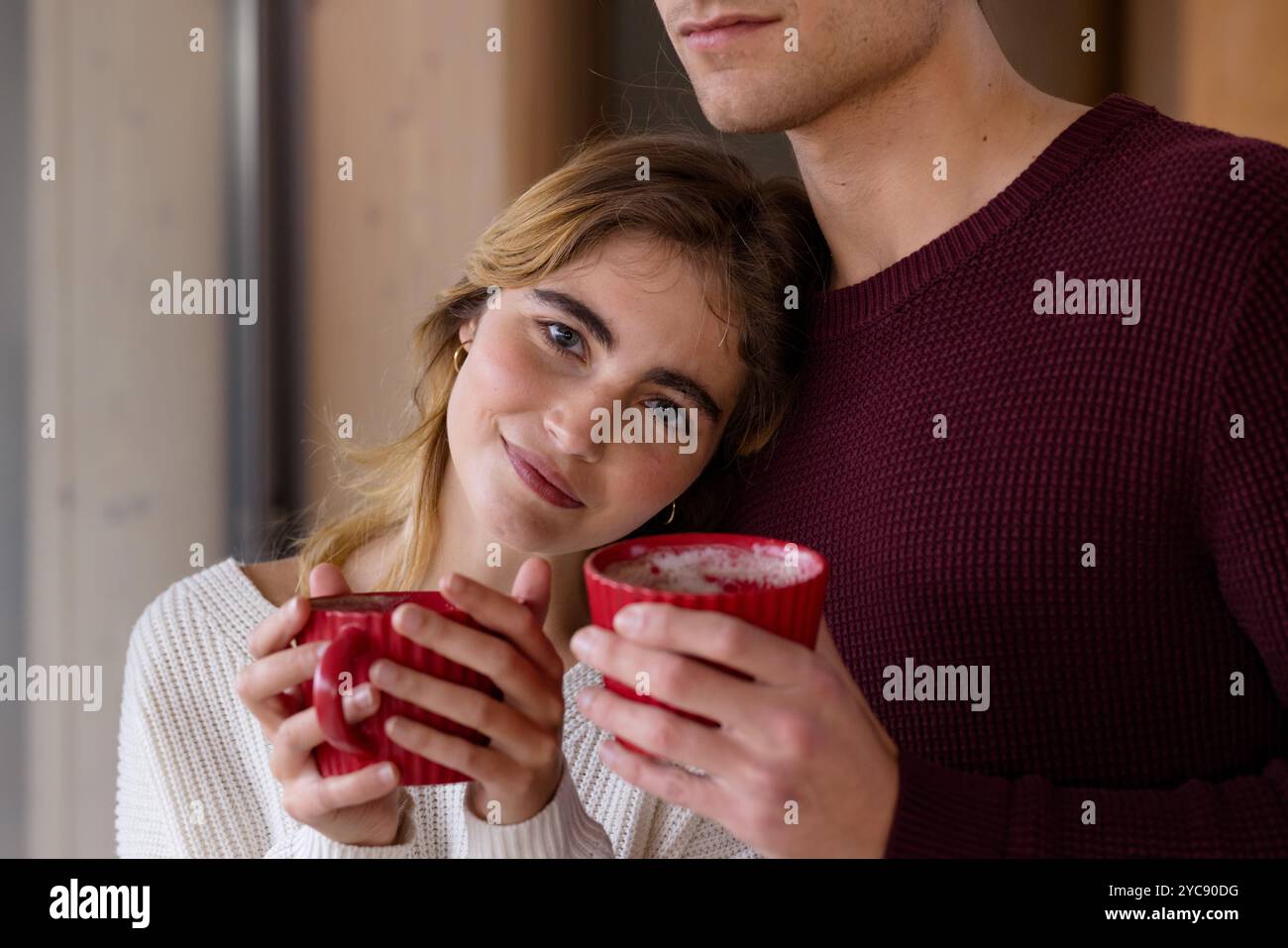 Couple confortable appréciant le chocolat chaud ensemble à la maison pendant la saison de Noël Banque D'Images