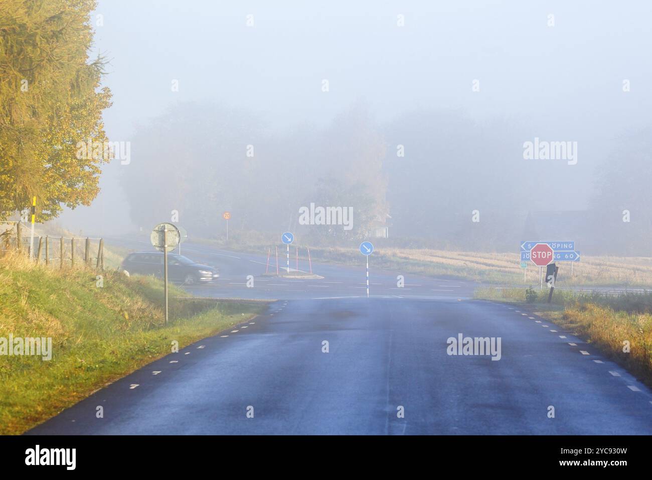 Brouillard à la croisée des chemins sur une route de campagne Banque D'Images