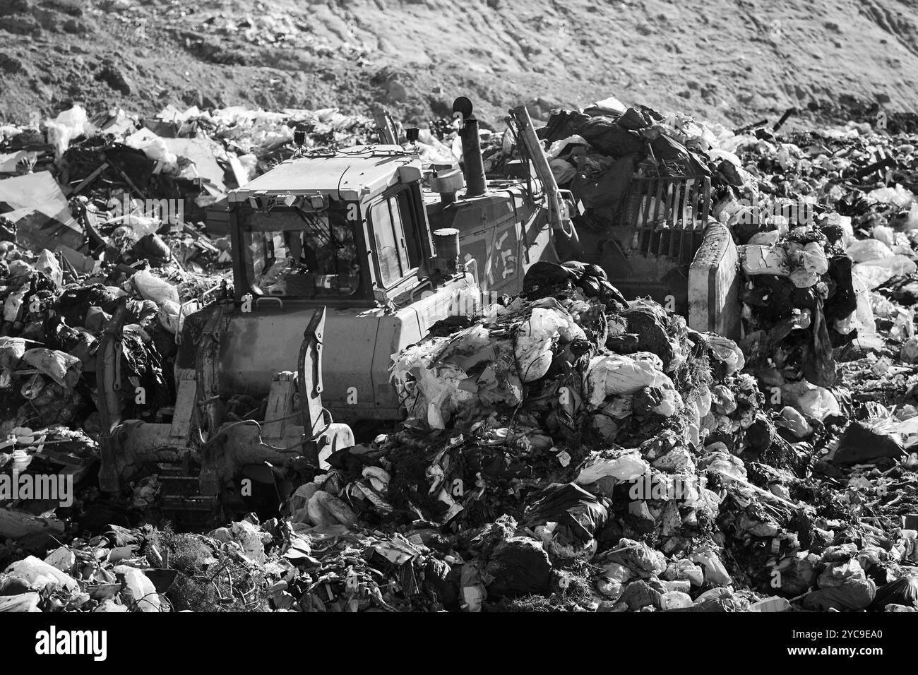 Les machines lourdes déchiquetent les déchets dans une décharge à ciel ouvert. Déchets Banque D'Images