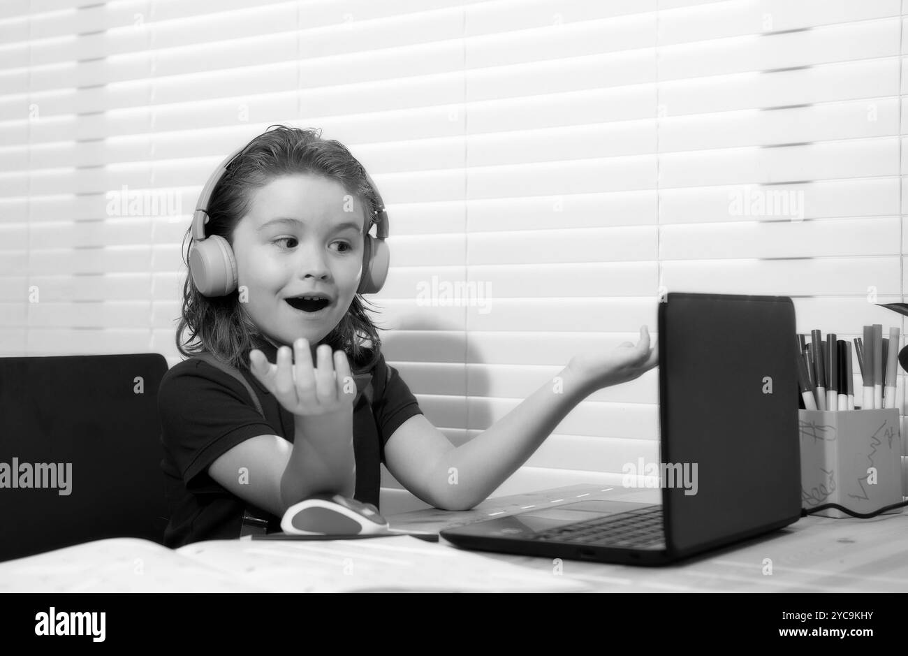 Le garçon d'école caucasien dans les écouteurs ont vidéo appel classe à distance avec l'enseignant utilisant l'ordinateur portable, heureux petit enfant vague salutation avec le tuteur, étudier en ligne Banque D'Images