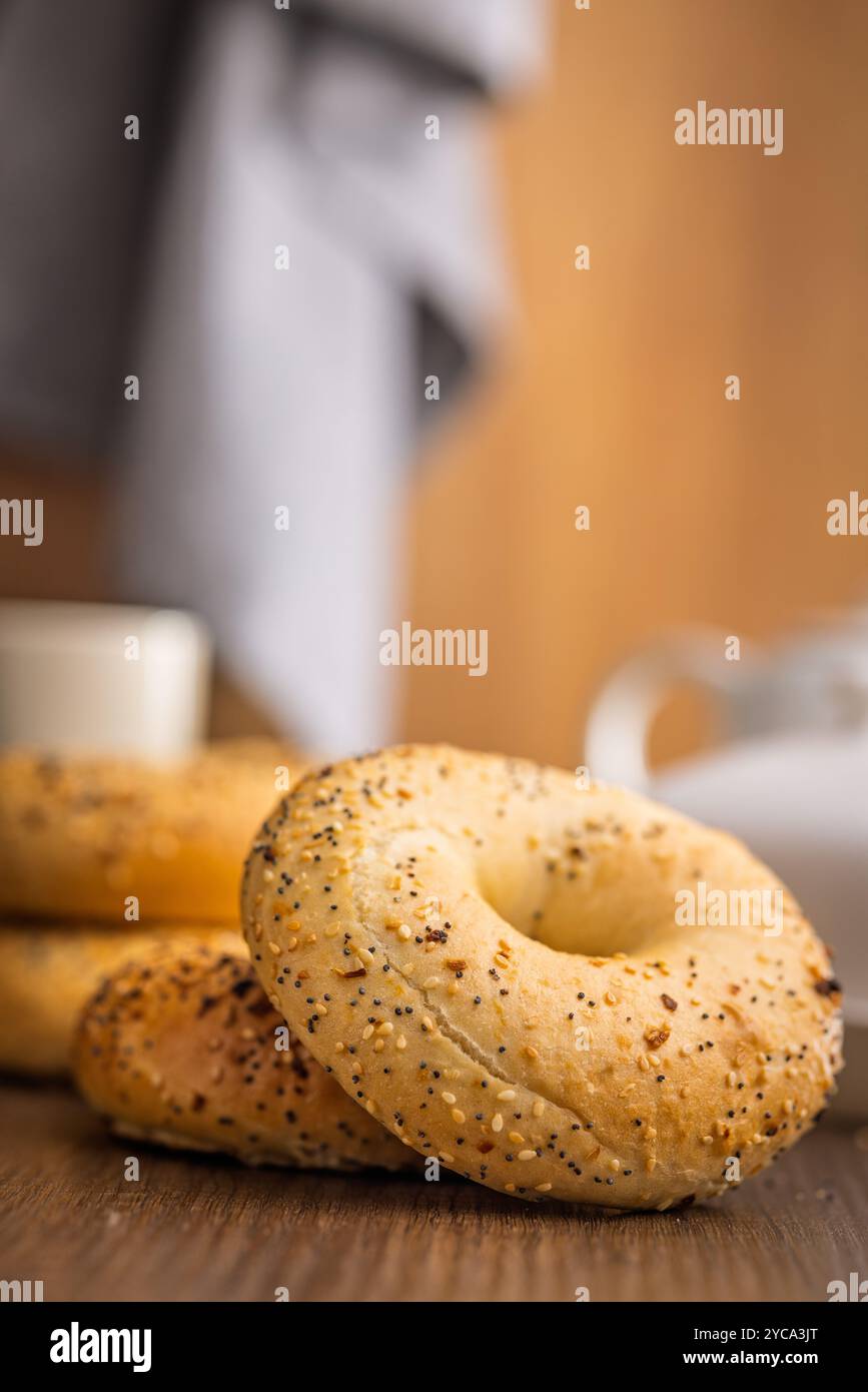 Bagel saupoudré d'oignon frit, de sésame et de graines de pavot sur une table en bois. Banque D'Images