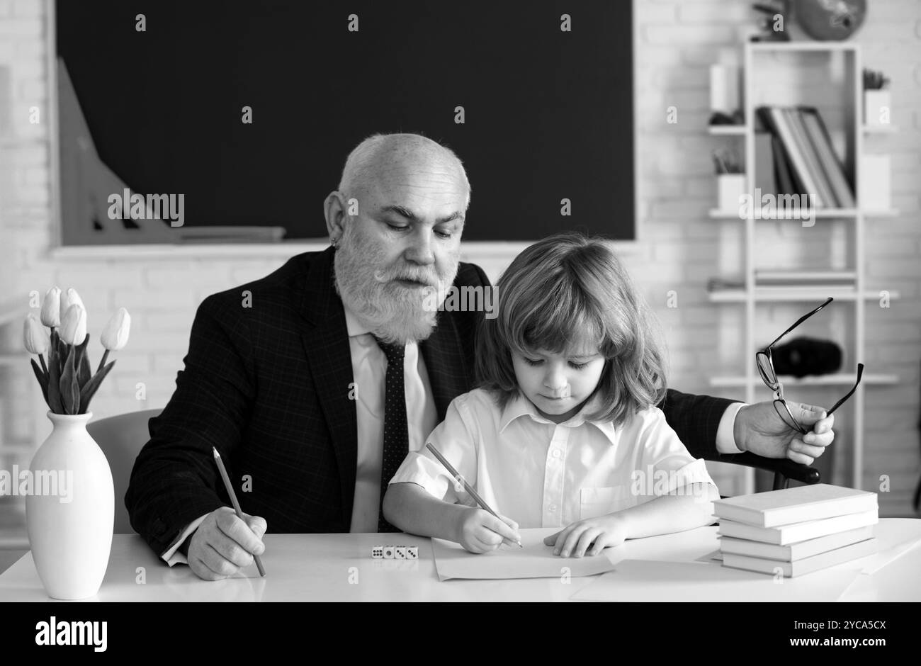 Leçon enfant élève. Enseignant principal. Concept d'éducation. Vieux grand-père enseignant avec écolier en classe. Banque D'Images