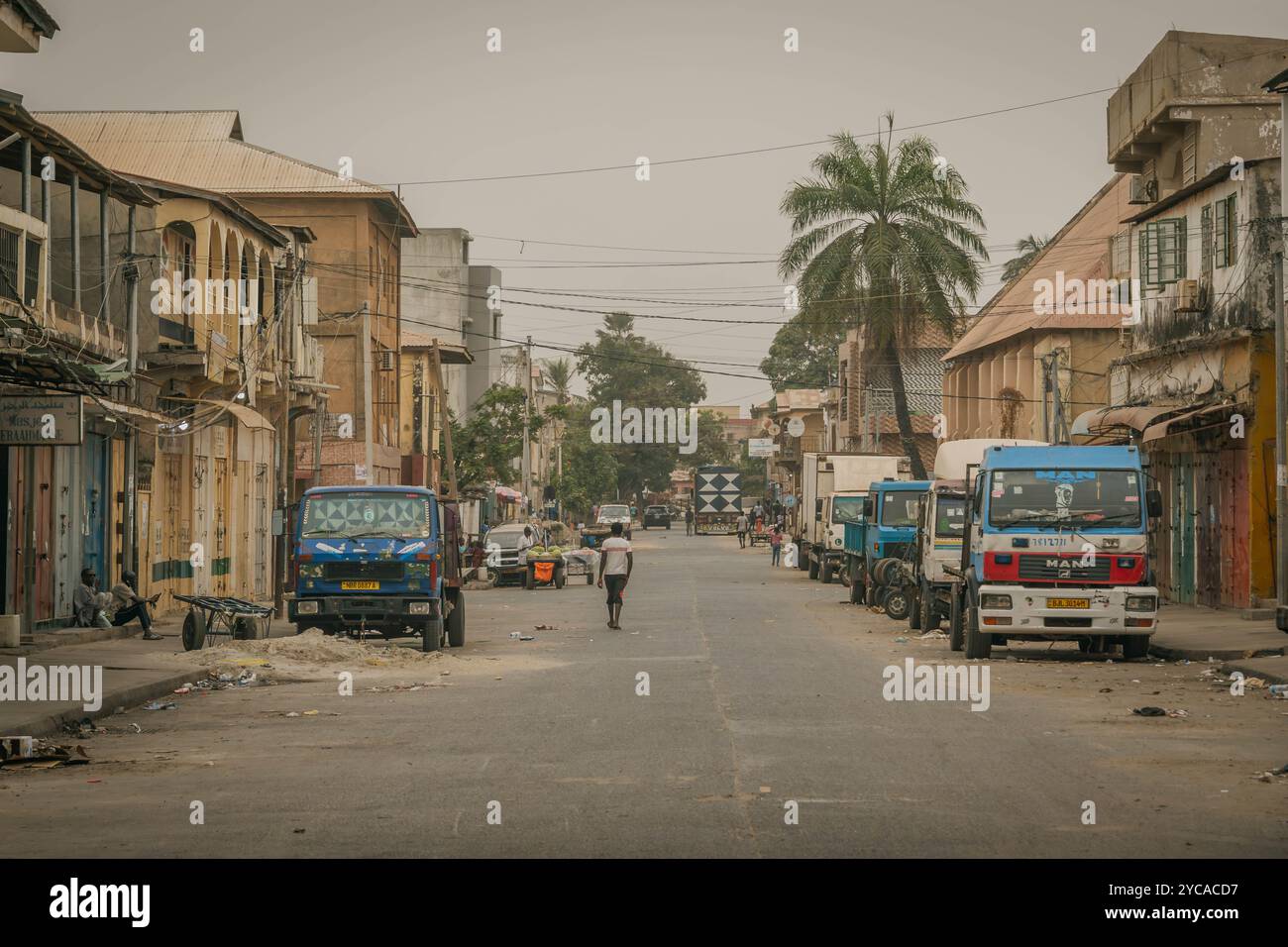 Les rues vides de Banjul, avec des ordures sur la route et de vieilles voitures africaines, à Gambie, Afrique de l'Ouest. Banque D'Images