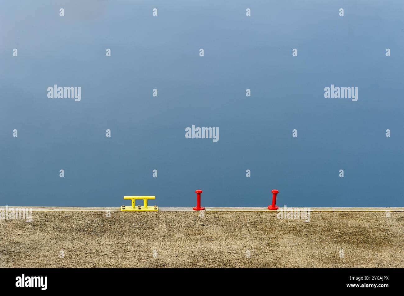 Les éléments aux couleurs vives se distinguent sur un fond bleu tranquille, créant un contraste visuel saisissant dans un cadre urbain. Banque D'Images