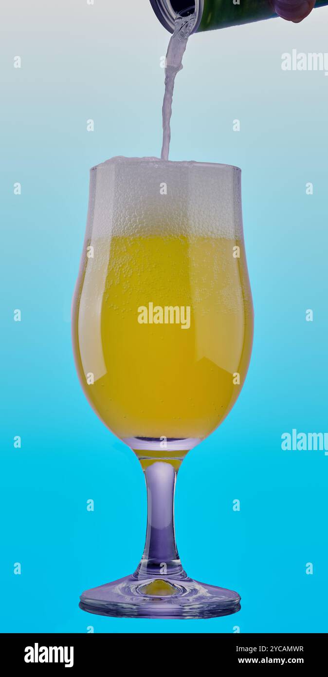 Boisson gazeuse froide versée dans un verre sur un fond bleu dégradé. Banque D'Images