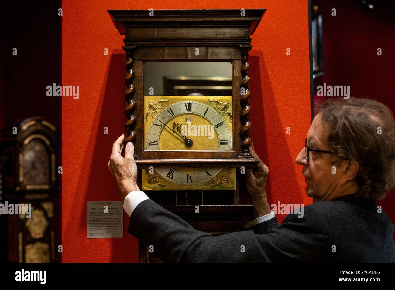 Londres, Royaume-Uni. 22 octobre 2024. Un membre du personnel avec une 'Thomas Tompion Londini Fecit', horloge Charles II longue case, vers 1675-80, sur le stand Howard Walwyn lors d'une avant-première de la foire LAPADA par l'Association of Art & Antiquités Dealers. Les revendeurs spécialisés présentent une gamme variée d'art, de design et d'antiquités avec une authenticité assurée grâce à un comité de spécialistes de 70 membres qui effectue le pré-contrôle de tout ce qui est en vente. La foire se déroule du 22 au 27 octobre à Berkeley Square. Credit : Stephen Chung / Alamy Live News Banque D'Images