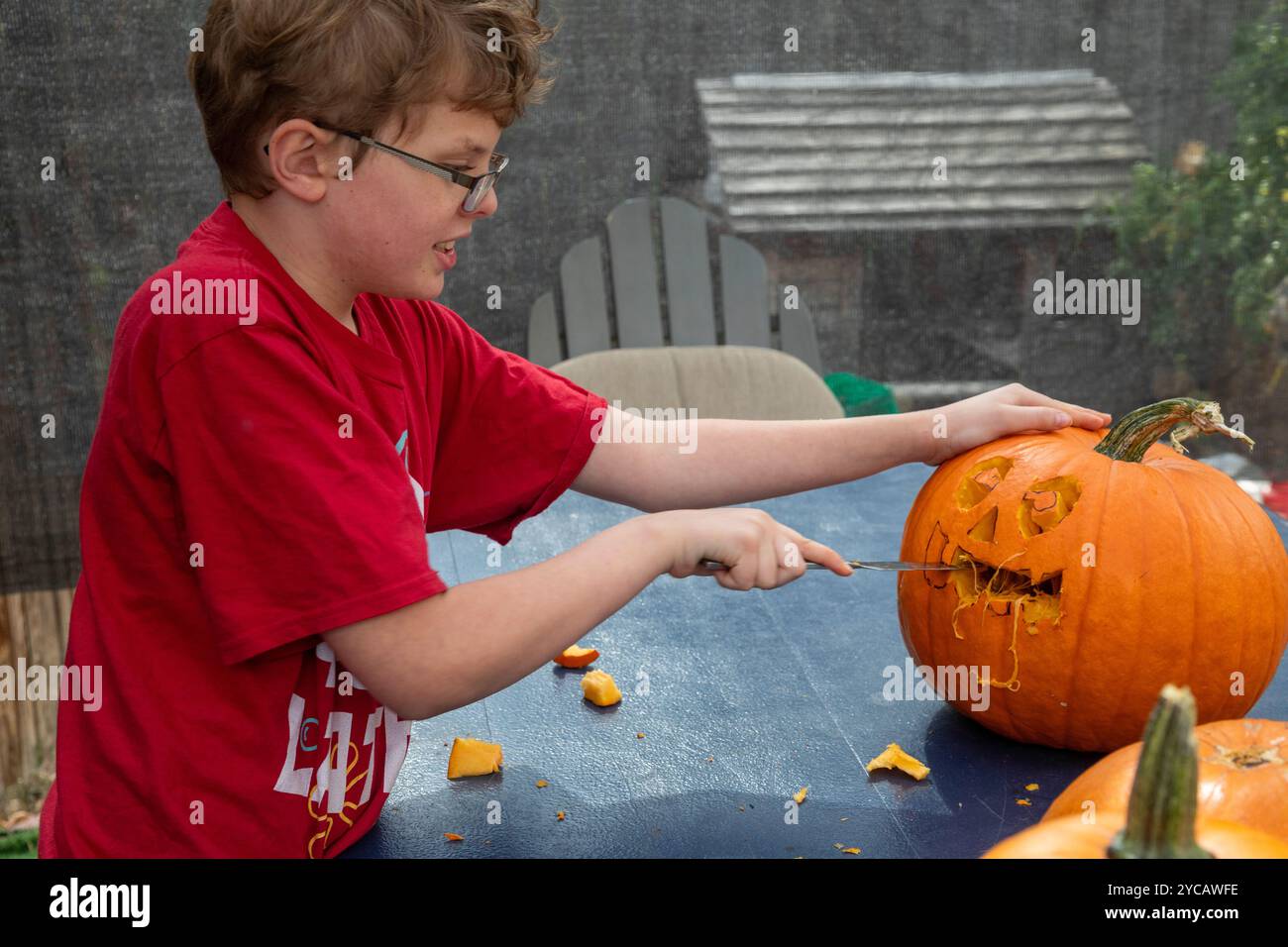 Denver, Colorado - Un garçon de dix ans sculpte une citrouille d'Halloween. Banque D'Images