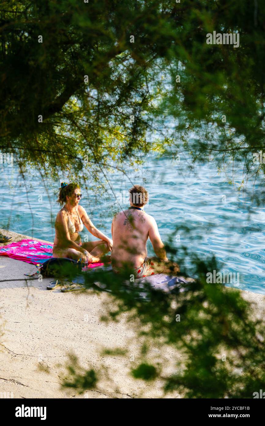 Homme et femme parlant et se relaxant à Bacvice Beach, Split, Croatie Banque D'Images