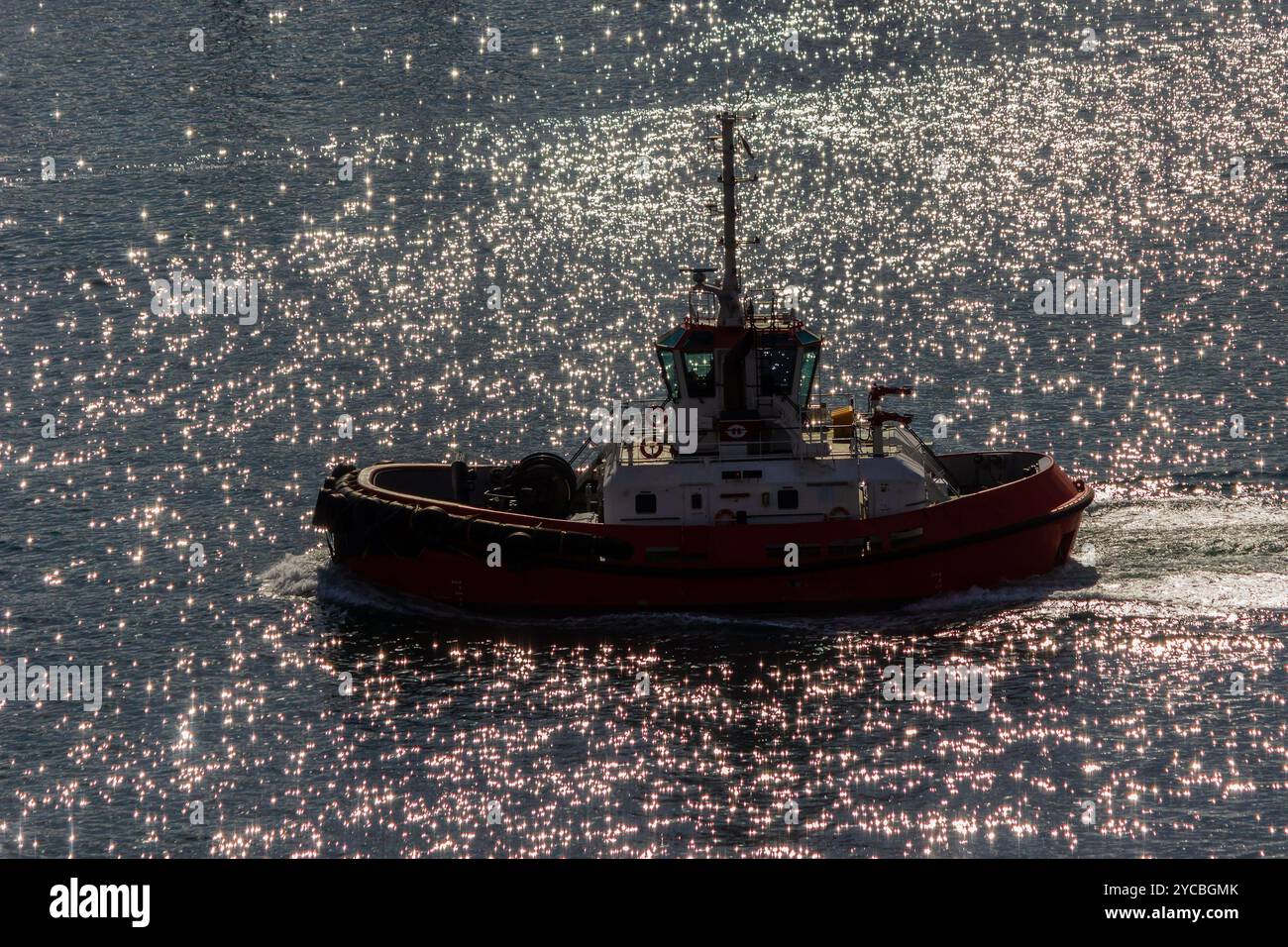 Red Tugboat naviguant dans l'océan bleu près de Stone Breakwater Banque D'Images