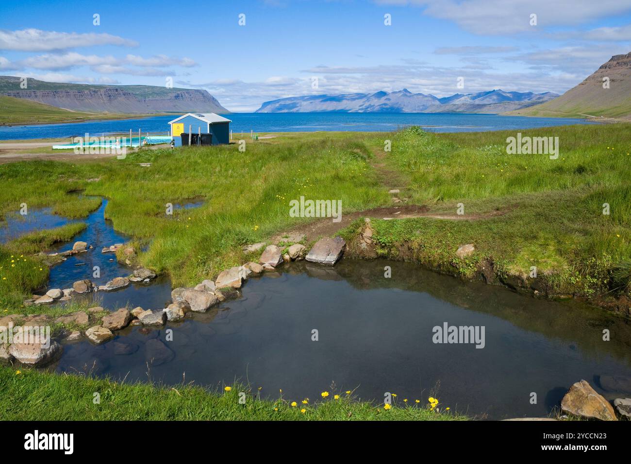 Piscine géothermique extérieure sur fond de montagnes et d'eau dans Westfjords, Islande Banque D'Images