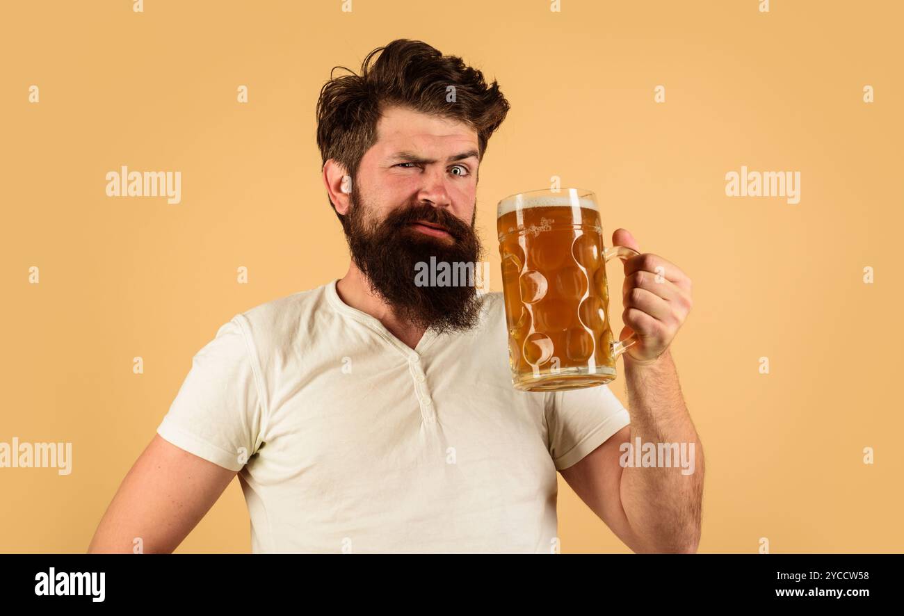 Pub ou bar à bière. Homme barbu surpris buvant une délicieuse bière lager au restaurant. Bière en Allemagne. Beau mâle en tenue décontractée avec mug de frais Banque D'Images