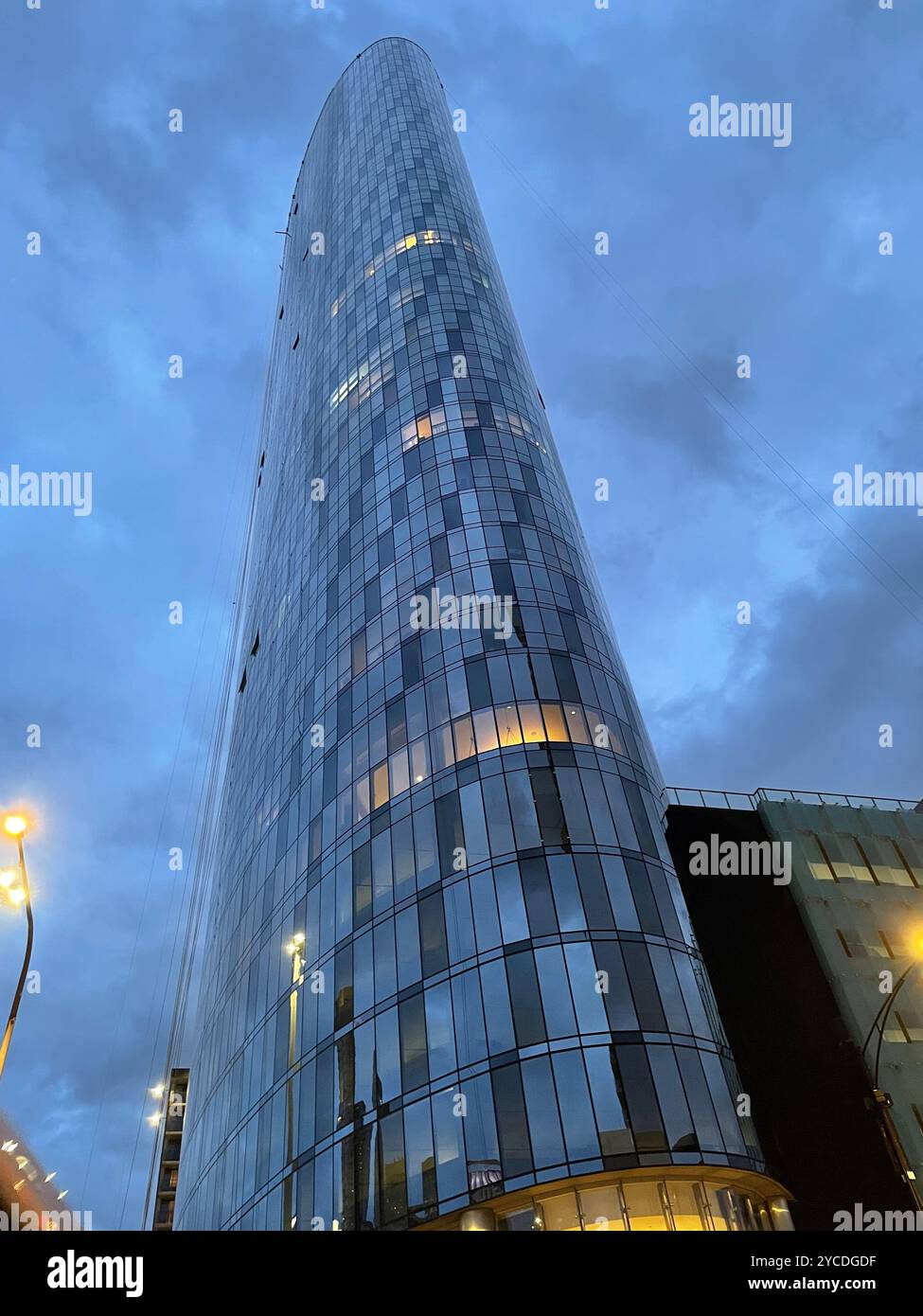 Gratte-ciel en verre moderne haut tourné d'en bas au crépuscule avec ciel nuageux. Capture l'architecture urbaine, l'échelle et la vie urbaine au crépuscule. - Image de stock capturée avec un smartphone