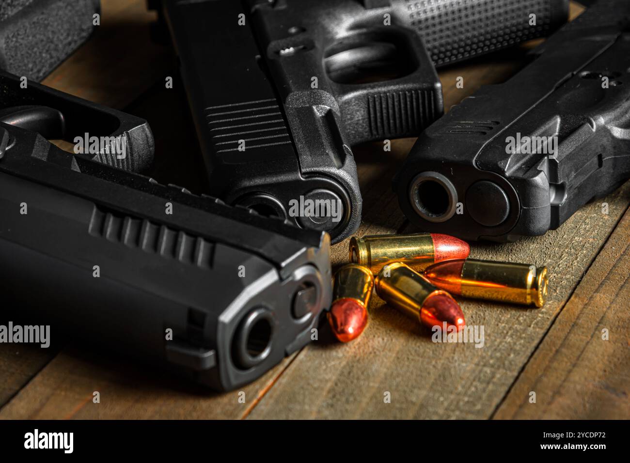 Diverses armes de poing disposées sur une table en bois avec quelques munitions PARA DE 9mm. Banque D'Images