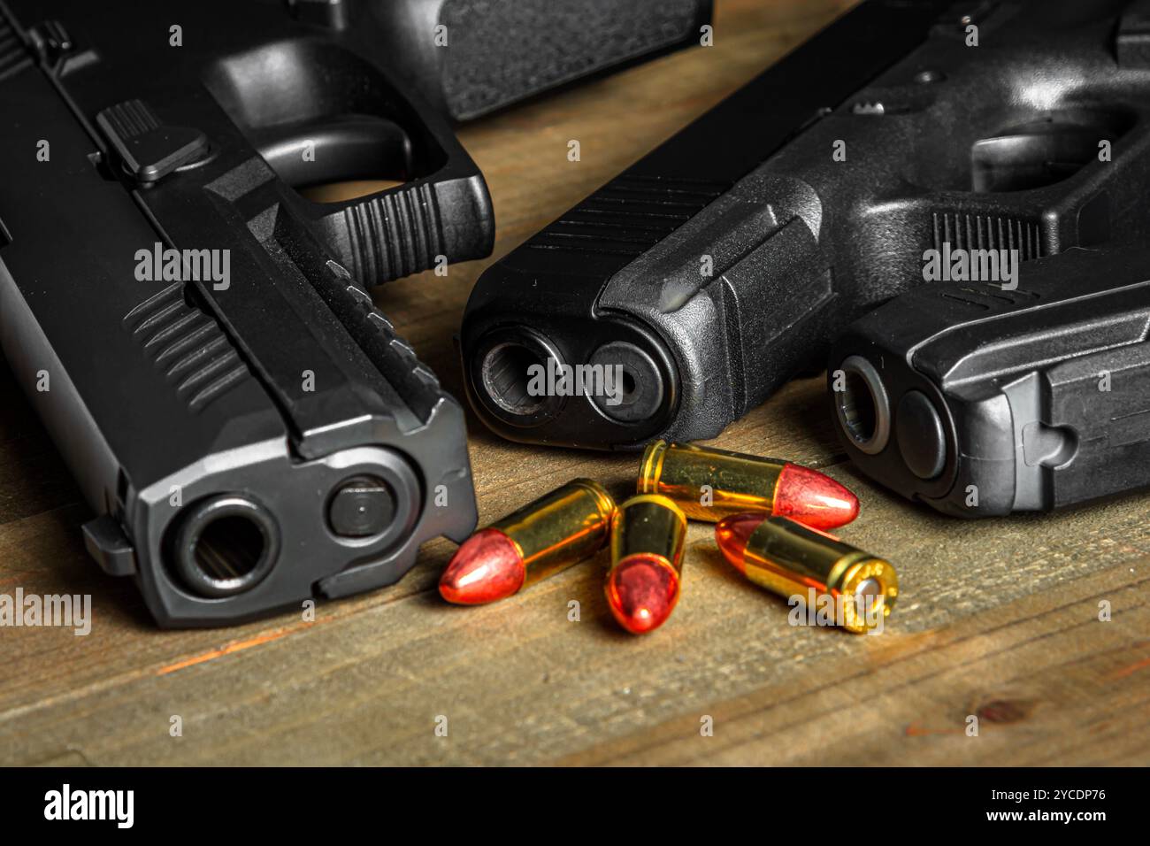 Diverses armes de poing disposées sur une table en bois avec quelques munitions PARA DE 9mm. Banque D'Images