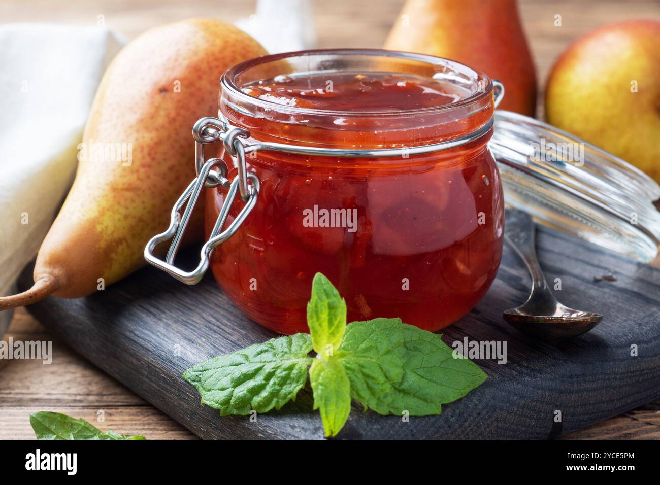 Confiture de poire fait maison dans un bocal et les poires fraîches sur un fond de bois Banque D'Images Confiture de poire fait maison dans un bocal et les poires fraîches sur un fond de bois Banque D'Images