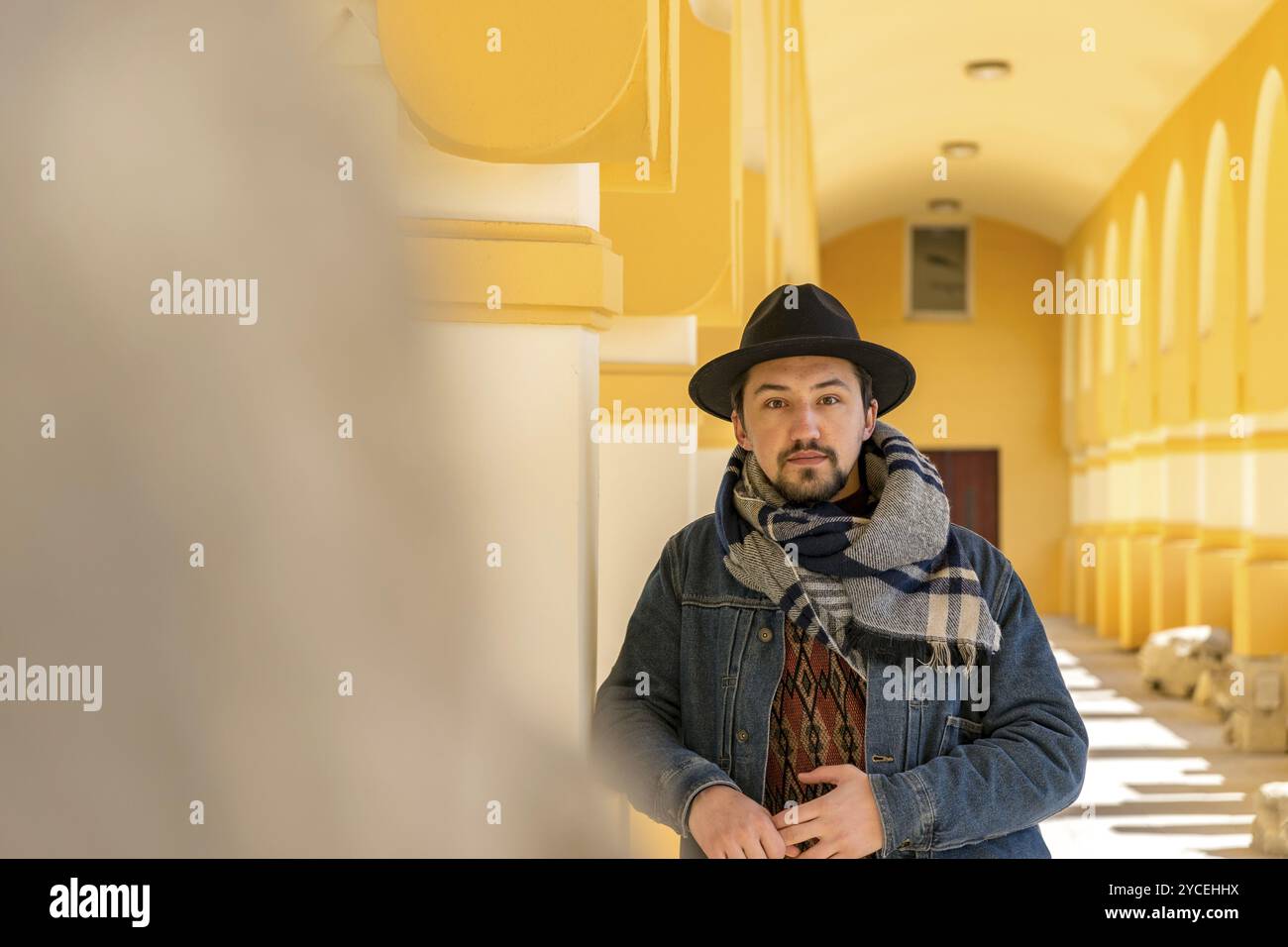 Portrait d'un beau jeune homme élégant avec une écharpe à l'extérieur. Un homme sérieux portant une écharpe, un chapeau et un jaket regardant confiant devant la caméra Banque D'Images