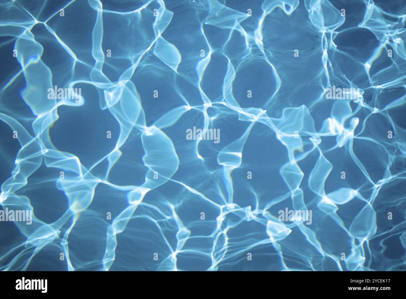 Reflet de la lumière du soleil dans l'eau d'une piscine avec fonte bleue Banque D'Images