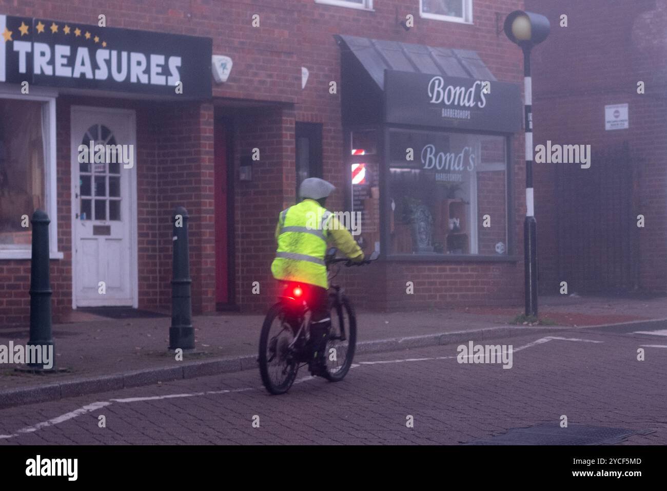 Fordingbridge, New Forest, Hampshire, Angleterre, Royaume-Uni, 23 octobre 2024 : les lumières sont allumées pour le cycliste en veste haute viz le matin d'automne brumeux. Paul Biggins/Alamy Live News Banque D'Images