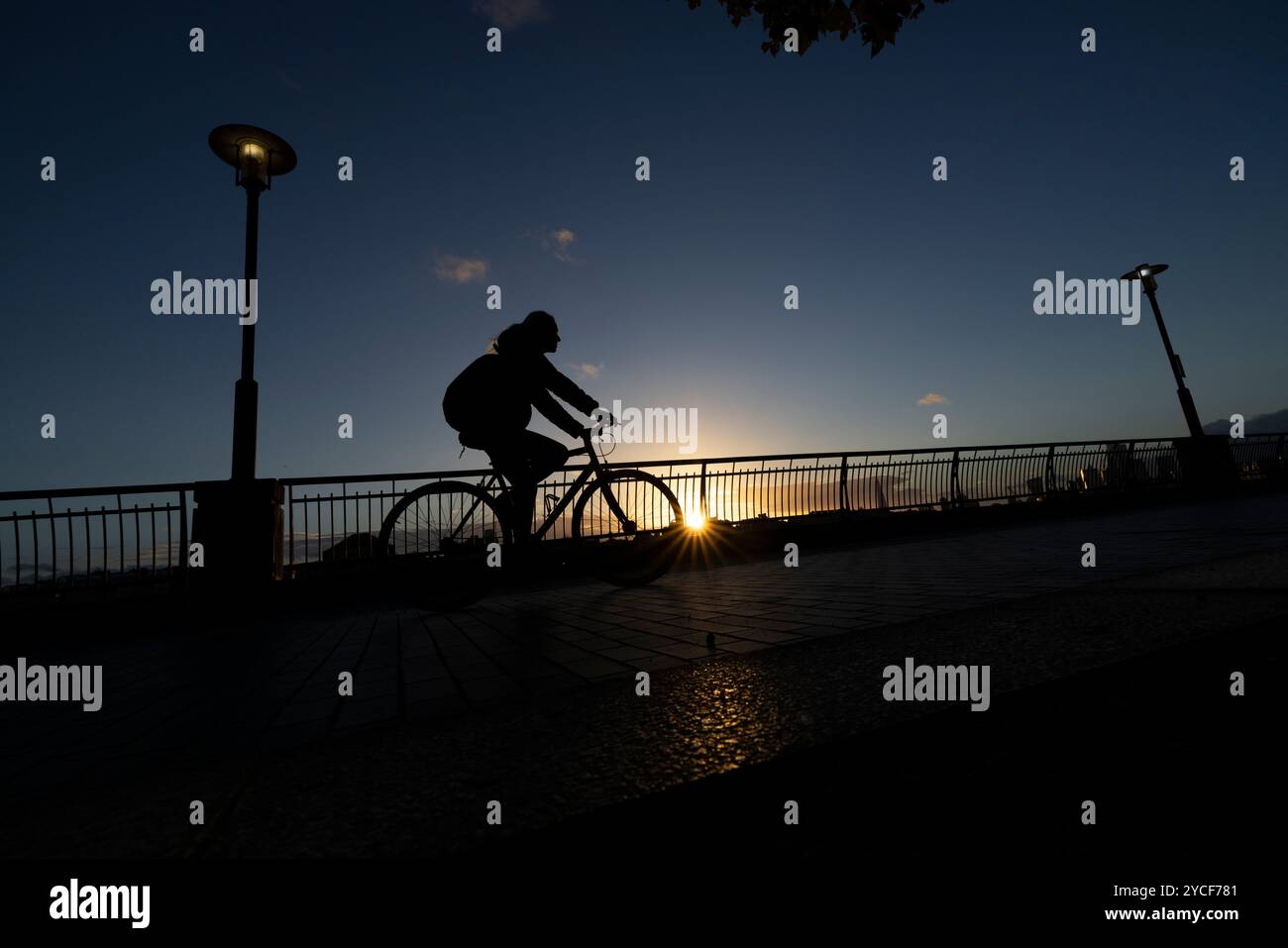 Les citadins qui rentrent chez eux pendant le coucher du soleil d'automne le long de la Tamise Pathway à Dundee Wharf, Westferry, Docklands, East London, Angleterre, ROYAUME-UNI Banque D'Images