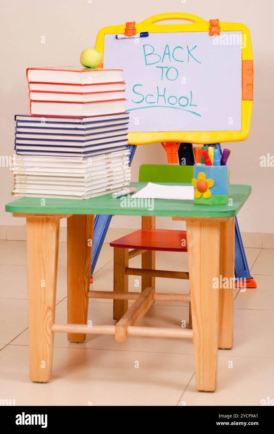 Livres scolaires et pomme sur le bureau avec sketchboard Banque D'Images