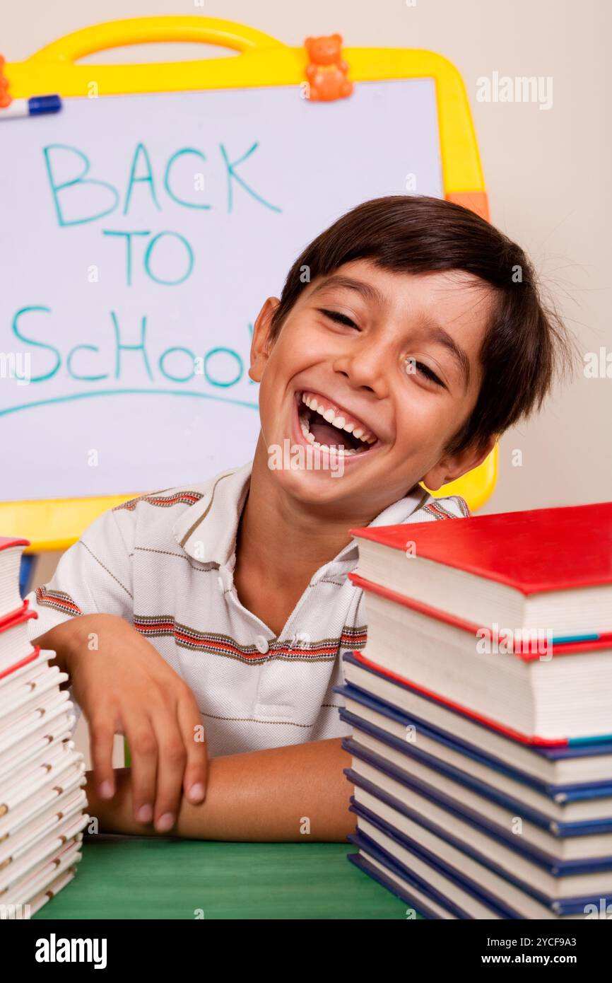 Garçon souriant avec des livres scolaires Banque D'Images