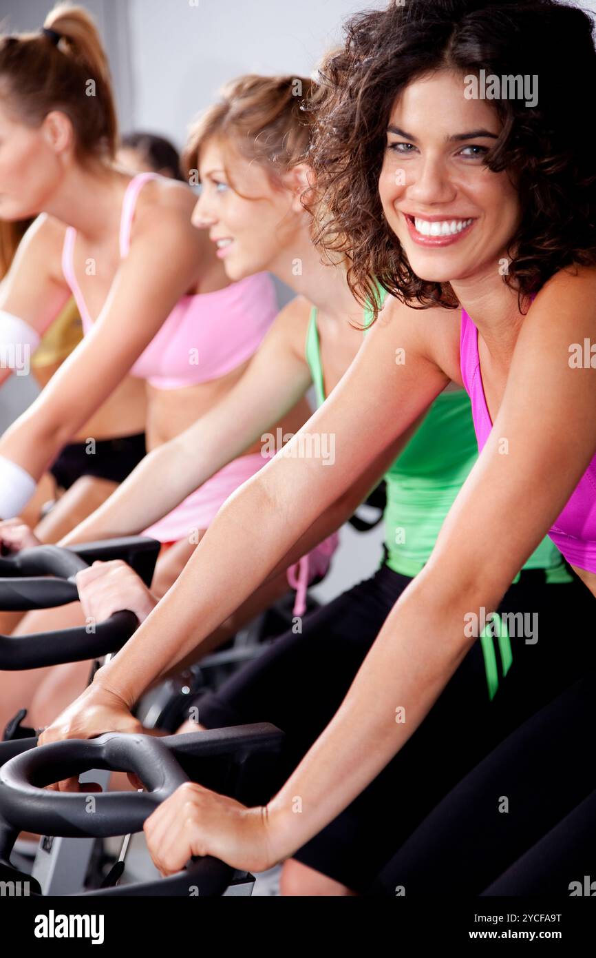 Les gens qui tournent sur des vélos dans une salle de gym Banque D'Images