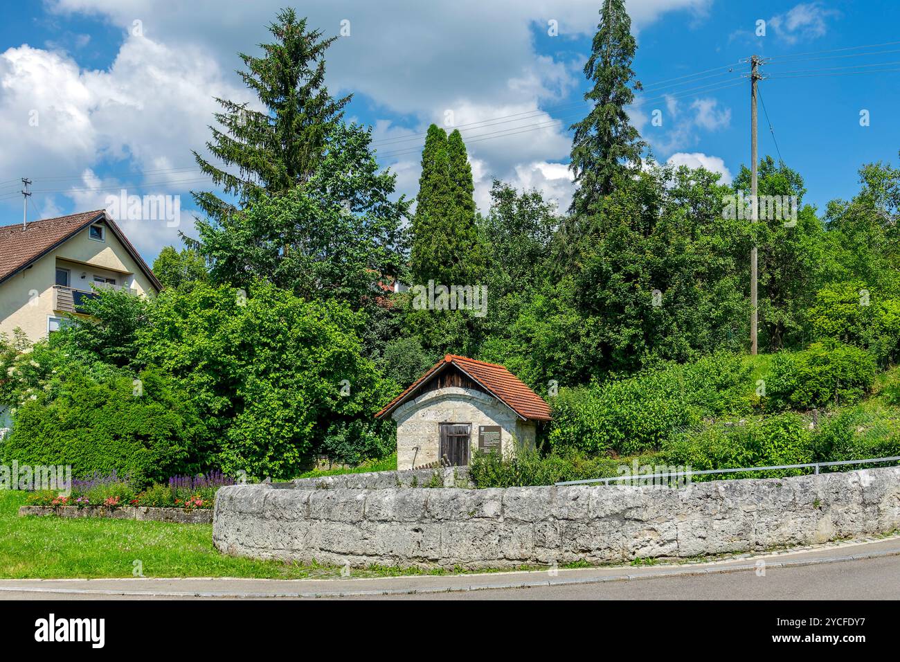 Allemagne, Bade-Württemberg, maison de printemps et Rossbrunnen à Lonsingen sur l'Alb souabe, le bassin de puits, construit en pierre naturelle vers 1800, est d'environ 7m de profondeur et a un diamètre de 12m. Banque D'Images