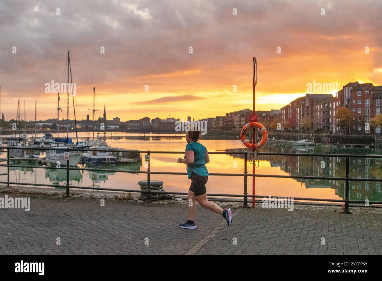 Preston, Lancashiure. Météo britannique. 23 octobre 2024. Lever de soleil calme et colurful sur la marina de yacht. Sunny sort brume discontinue et brouillard pour commencer que les joggeurs profitent d'un circuit des quais.. Crédit ; MediaWorld images/AlamyLiveNews Banque D'Images