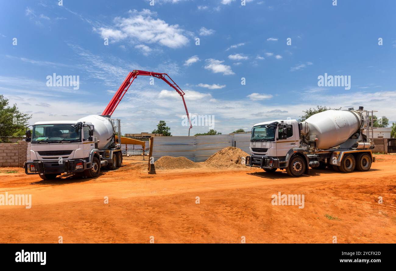 une pompe à béton de boom et un camion malaxeur de béton sur le chantier de construction Banque D'Images