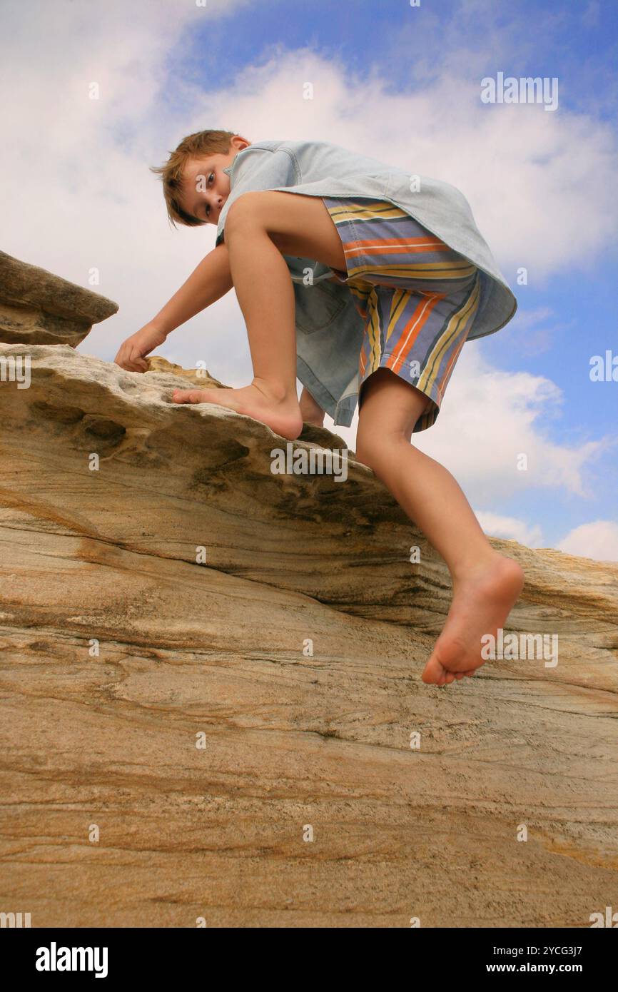 Enfant grimpant sur des rochers Banque D'Images