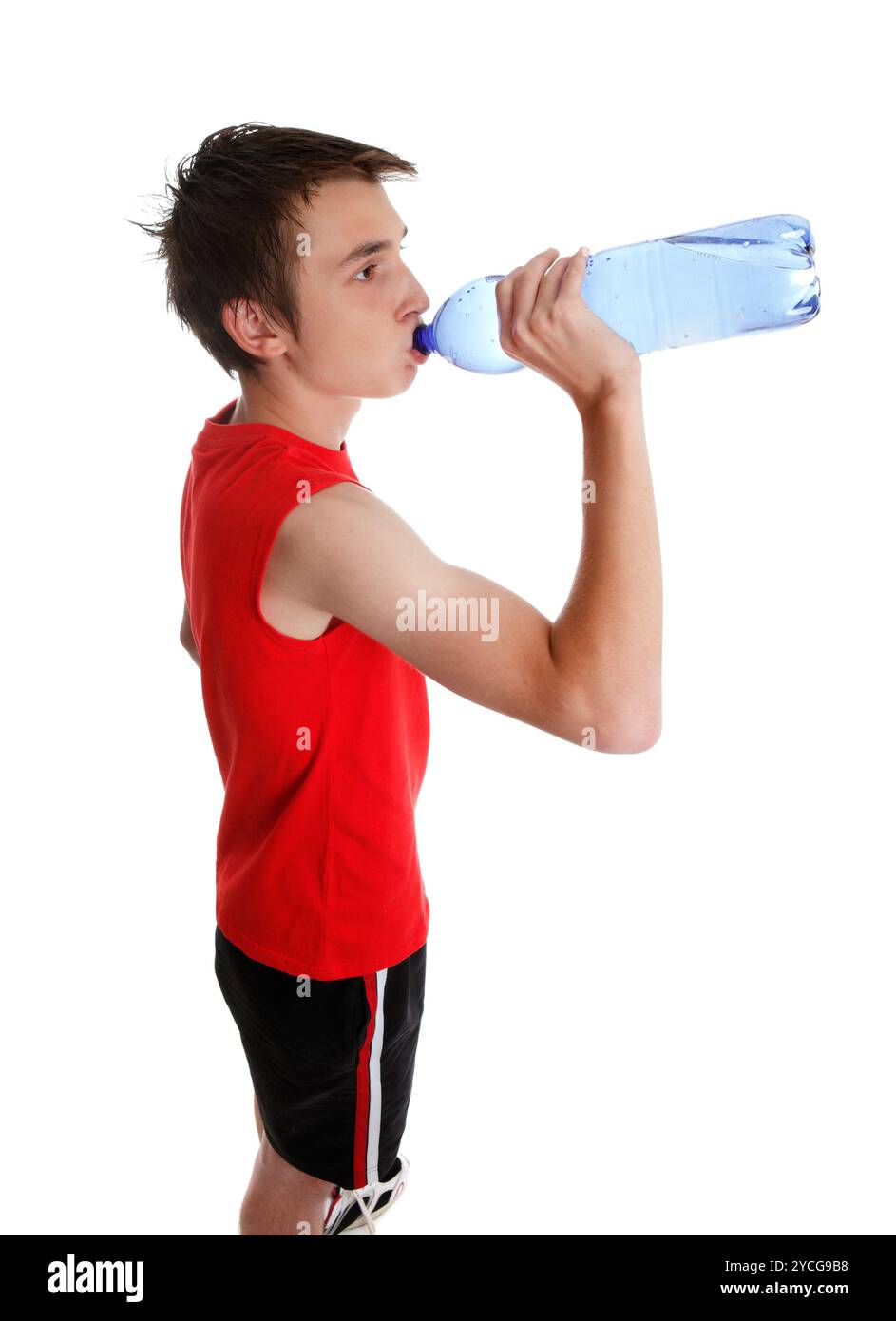 Un jeune adolescent buvant de l'eau en bouteille. Fond blanc Banque D'Images