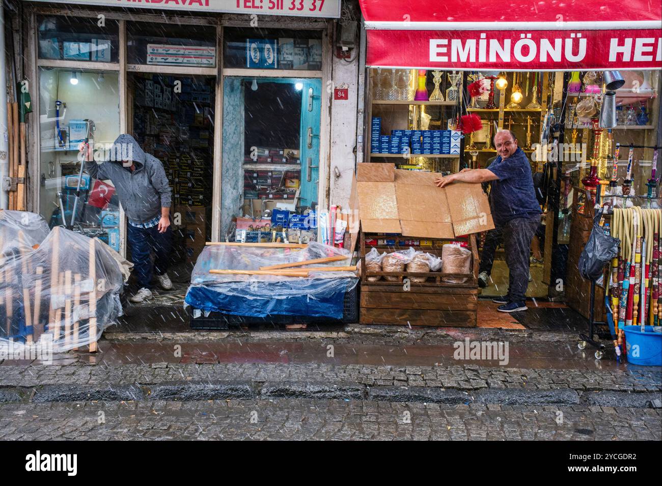 Les commerçants protègent leurs marchandises contre les mouillages lors d'une tempête de pluie soudaine, Istanbul, Turquie, 2024 Banque D'Images