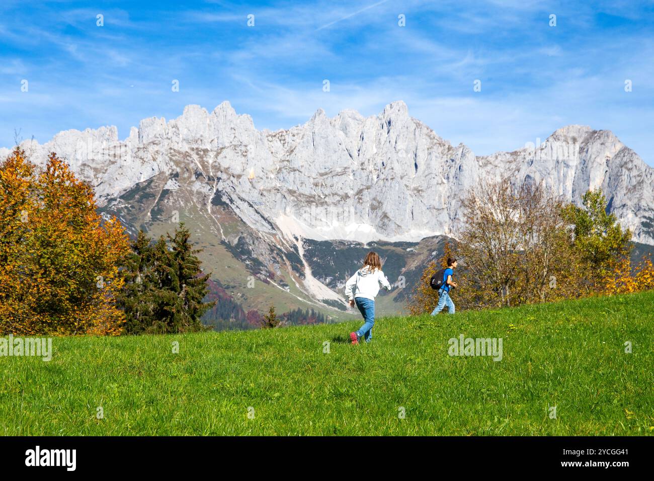 Randonnée avec les enfants au Tyrol : les enfants sur une prairie alpine avec pour toile de fond le Wilder Kaiser Banque D'Images