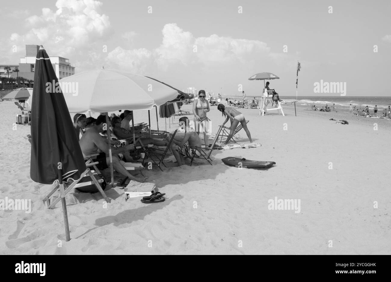 Touristes installant des chaises de plage sous parasols le long du Grand Strand à Myrtle Beach, Caroline du Sud, États-Unis. Banque D'Images