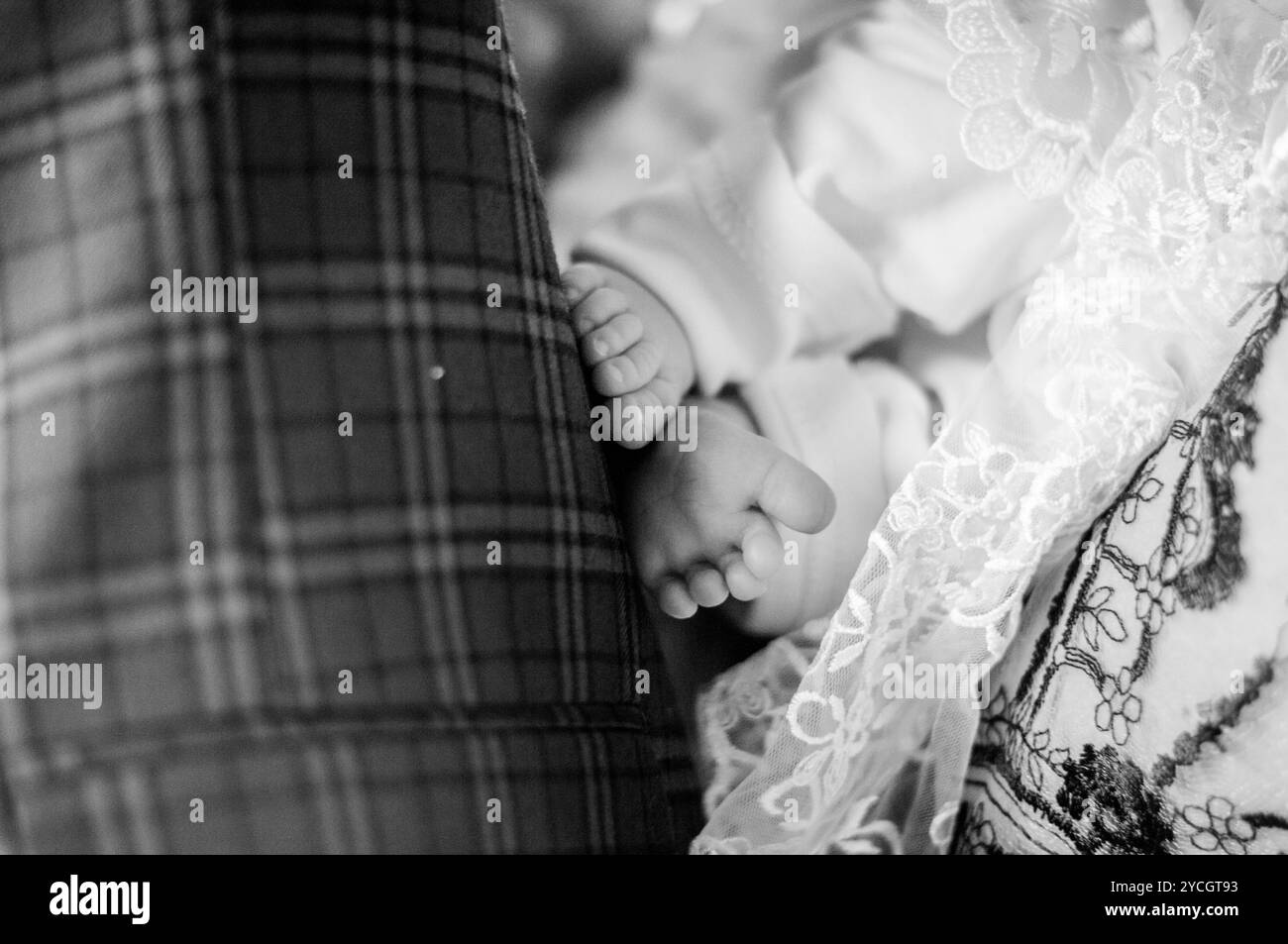 Étreinte délicate des pieds d'un nouveau-né capturé en Monochrome serein. Banque D'Images