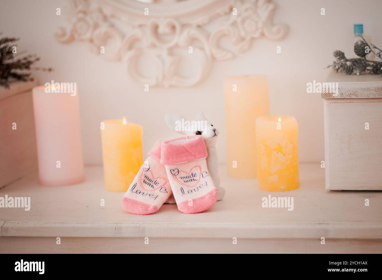 Décor lapin confortable avec chaussons roses et bougies. Banque D'Images