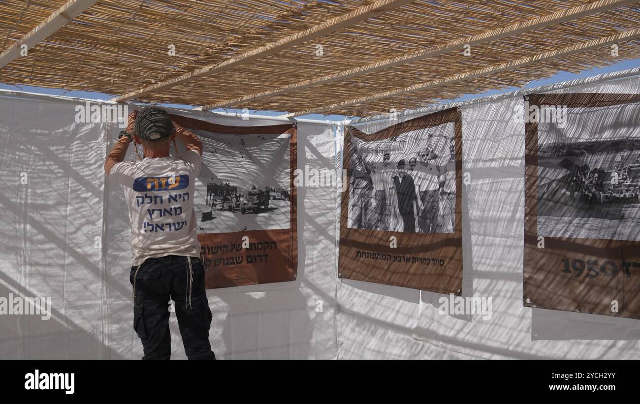 FRONTIÈRE SUD, ISRAËL - 21 OCTOBRE : un religieux juif porte un T-shirt disant "Gaza fait partie de la terre d'Israël" alors que des militants de droite et ultranationalistes se rassemblent dans un campement pendant une fête de Sukkoth dans une zone militaire fermée, près de la frontière avec Gaza pour discuter du rétablissement des communautés juives dans la bande de Gaza le 21 octobre 2024 à la frontière sud, en Israël. Banque D'Images