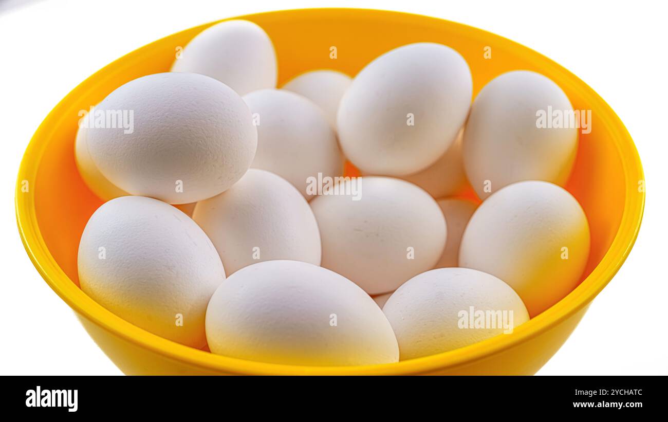 Un groupe d'œufs de poule sur un récipient en plastique jaune. Banque D'Images