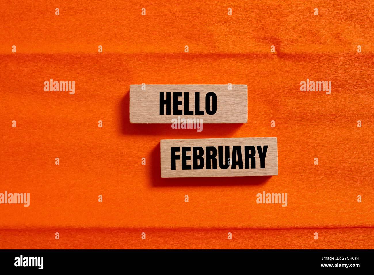 Bonjour février message écrit sur des blocs de bois avec fond orange. Symbole conceptuel bonjour février. Copier l'espace. Banque D'Images