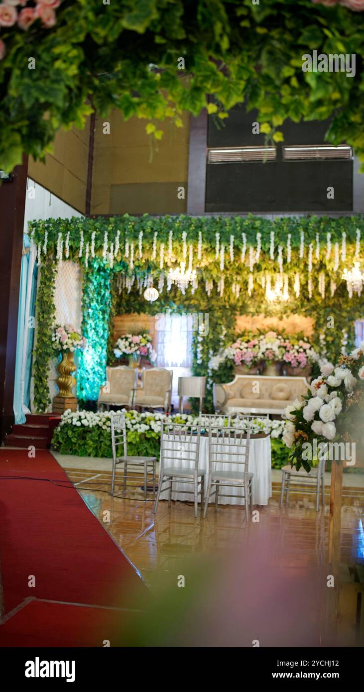Scène de mariage, appelée pelaminan en Indonésie, décorée de fleurs diverses Banque D'Images