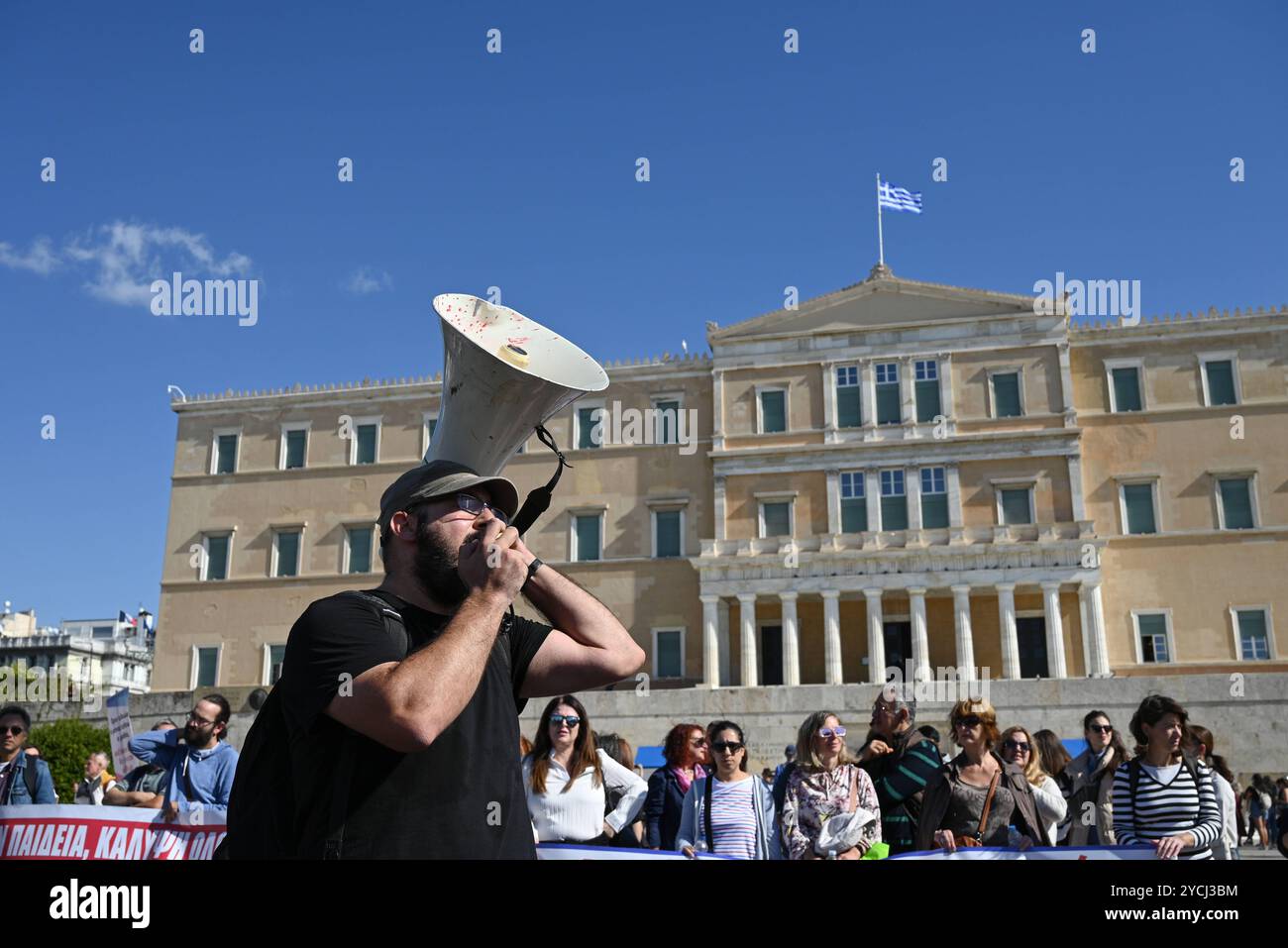 Les enseignants grecs protestent pour une meilleure rémunération Un manifestant chante des slogans utilisant un mégaphone alors que les enseignants des écoles maternelles et primaires manifestent devant le Parlement grec pour exiger des augmentations de salaire. Athènes Grèce Copyright : xNicolasxKoutsokostasxNicolasxKoutsokostasx DSC 202410230513 Banque D'Images