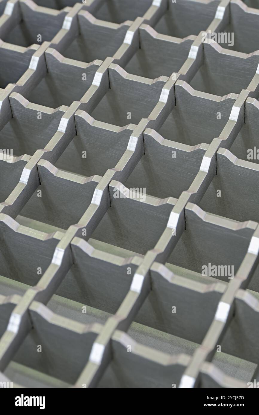 Grille tridimensionnelle en acier avec alvéoles carrées, revêtement de sol antidérapant pour installations industrielles. Fond géométrique abstrait de métallurgie. Banque D'Images