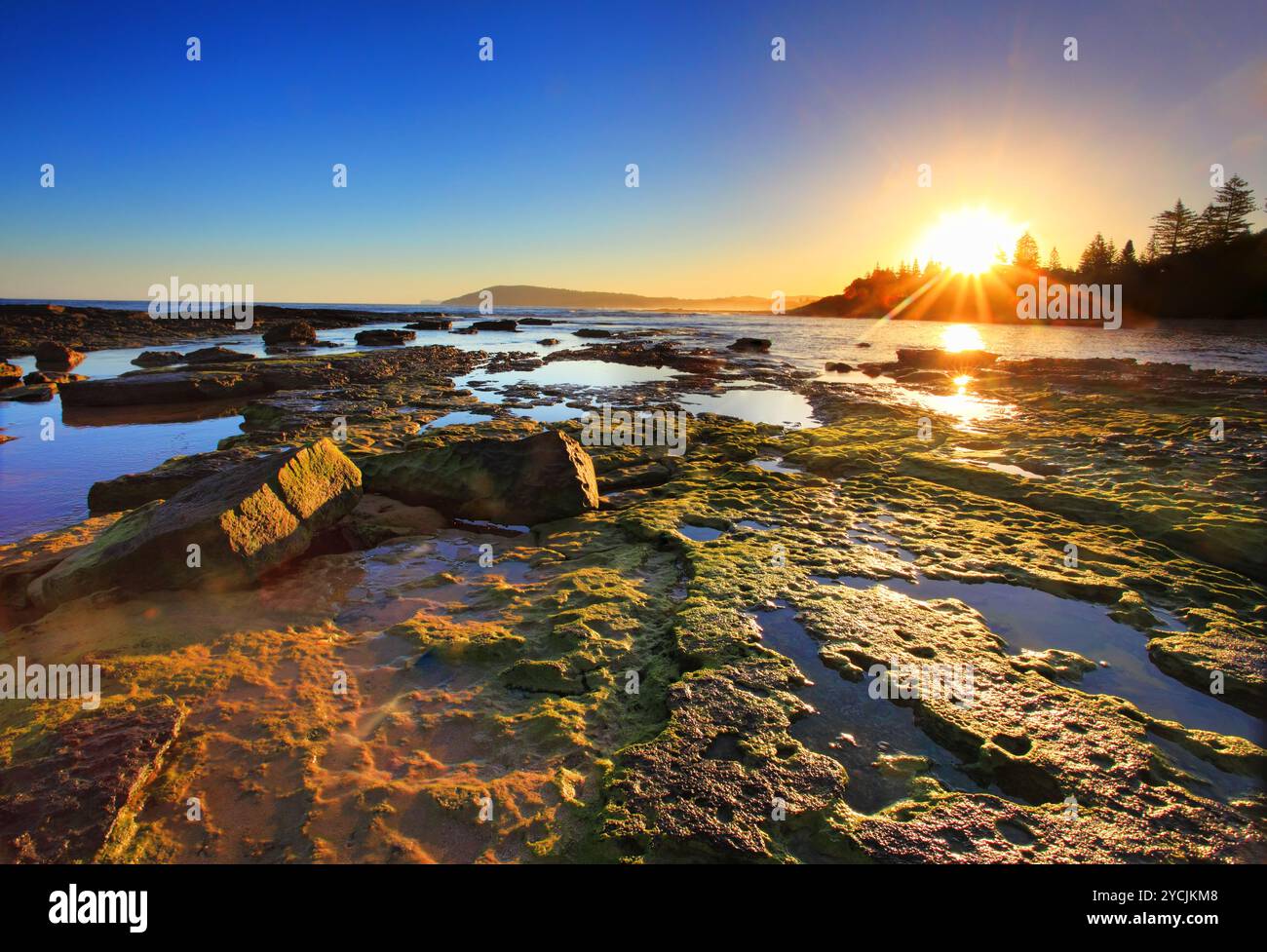Soleil d'or s'étendent à travers les récifs au coucher du soleil Banque D'Images