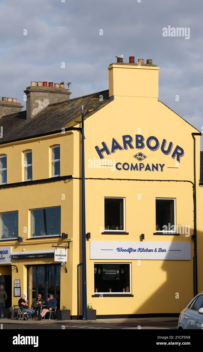 Hommes assis devant le bar-restaurant de la ville côtière Harbour et Company Donaghadee County Down. Banque D'Images