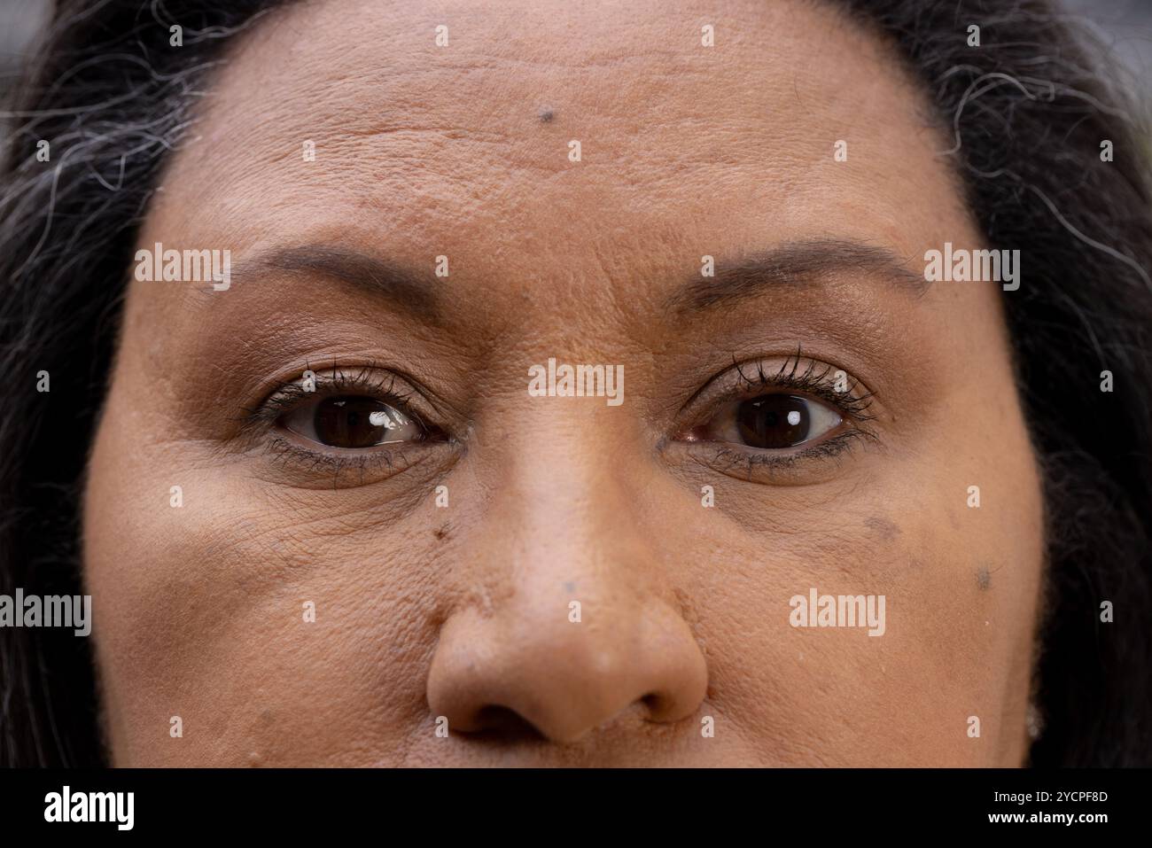 Gros plan des yeux de la femme senior, transmettant la sagesse et l'expérience de vie, à la maison Banque D'Images