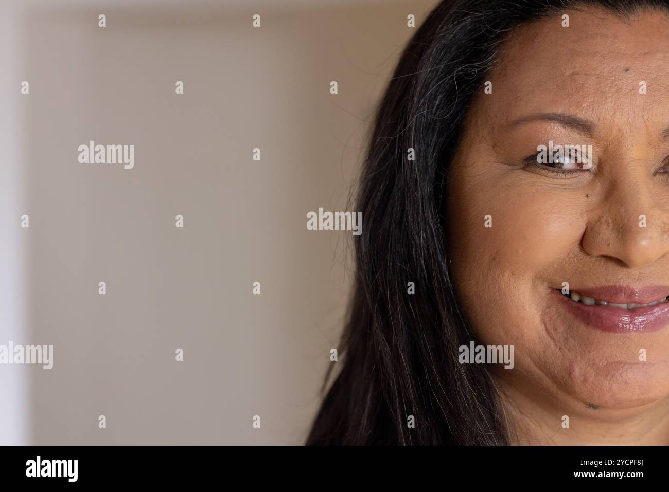 Femme senior souriante décorant la maison avec des décorations et des lumières de vacances festives, espace de copie Banque D'Images