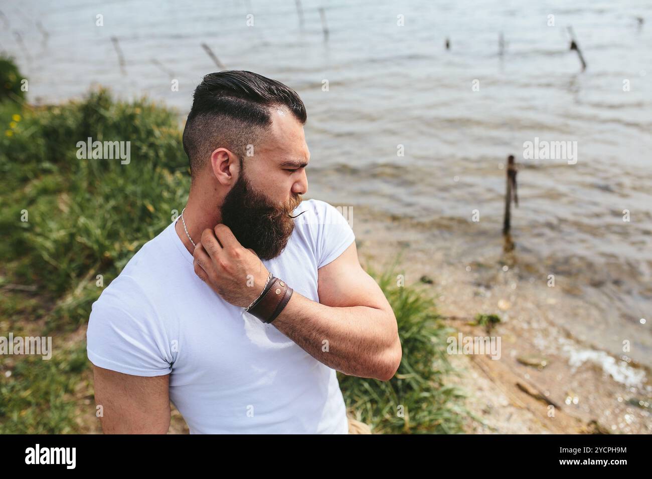 Homme barbu américain attend sur la rive du fleuve Banque D'Images