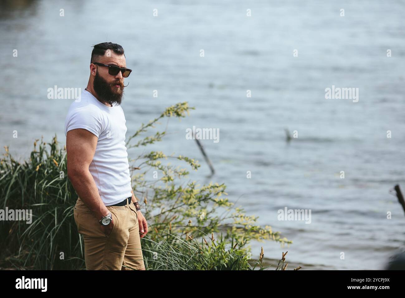 Homme barbu américain attend sur la rive du fleuve Banque D'Images