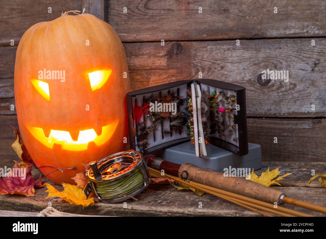 Tête de citrouille d'Halloween avec tacles de pêche à la mouche Banque D'Images Tête de citrouille d'Halloween avec tacles de pêche à la mouche Banque D'Images